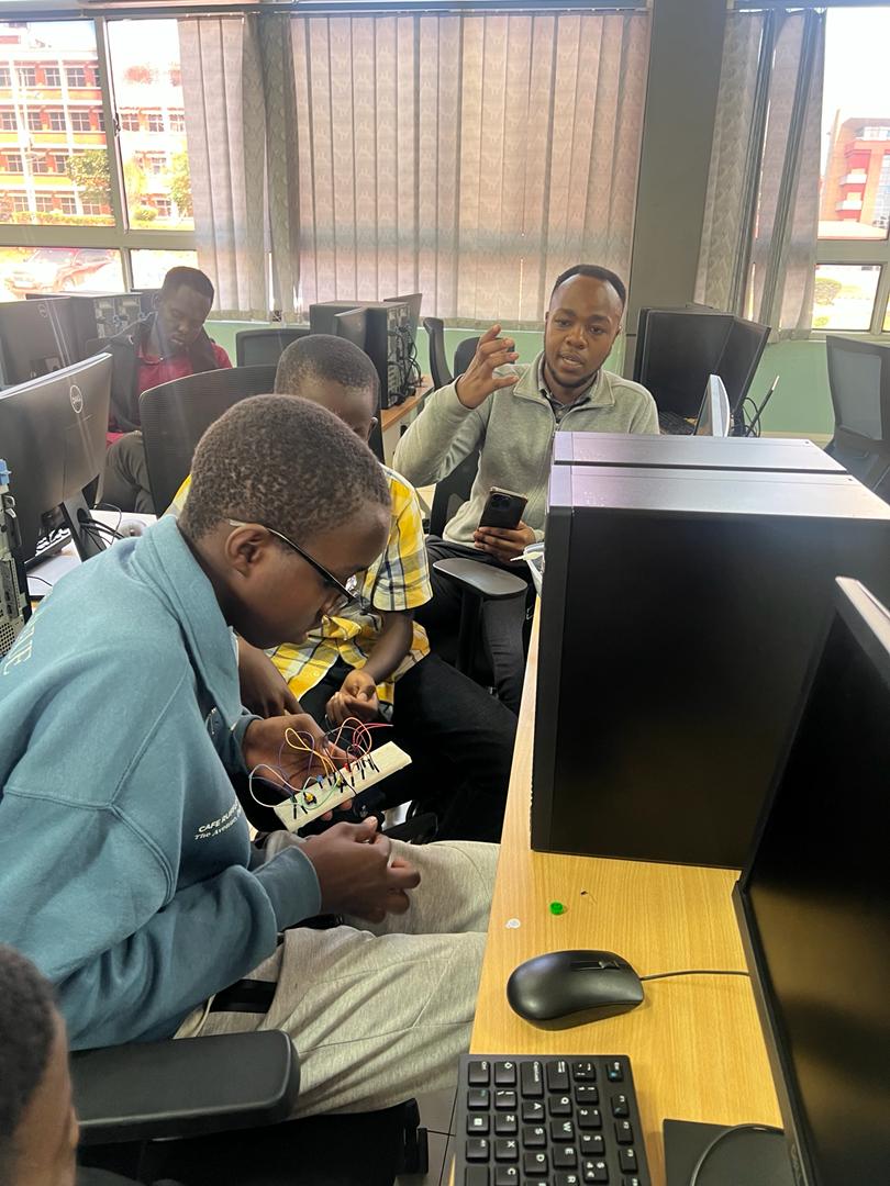 A tutor teaching a group of learners in a computer lab